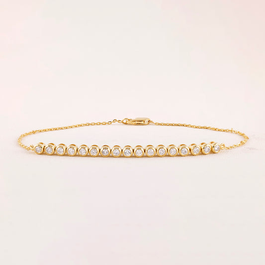 Gold bracelet with diamonds on a light beige background