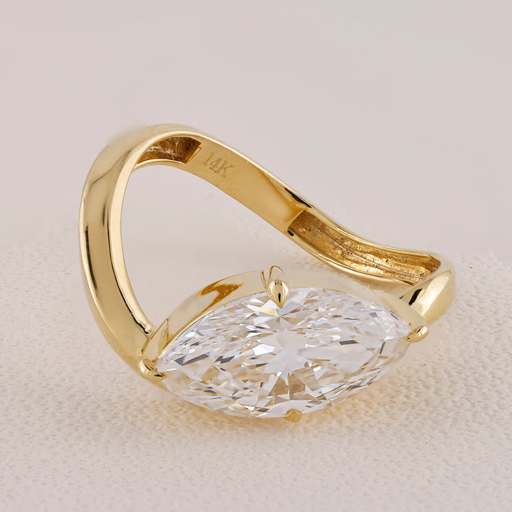 Gold ring with a large diamond on a light background
