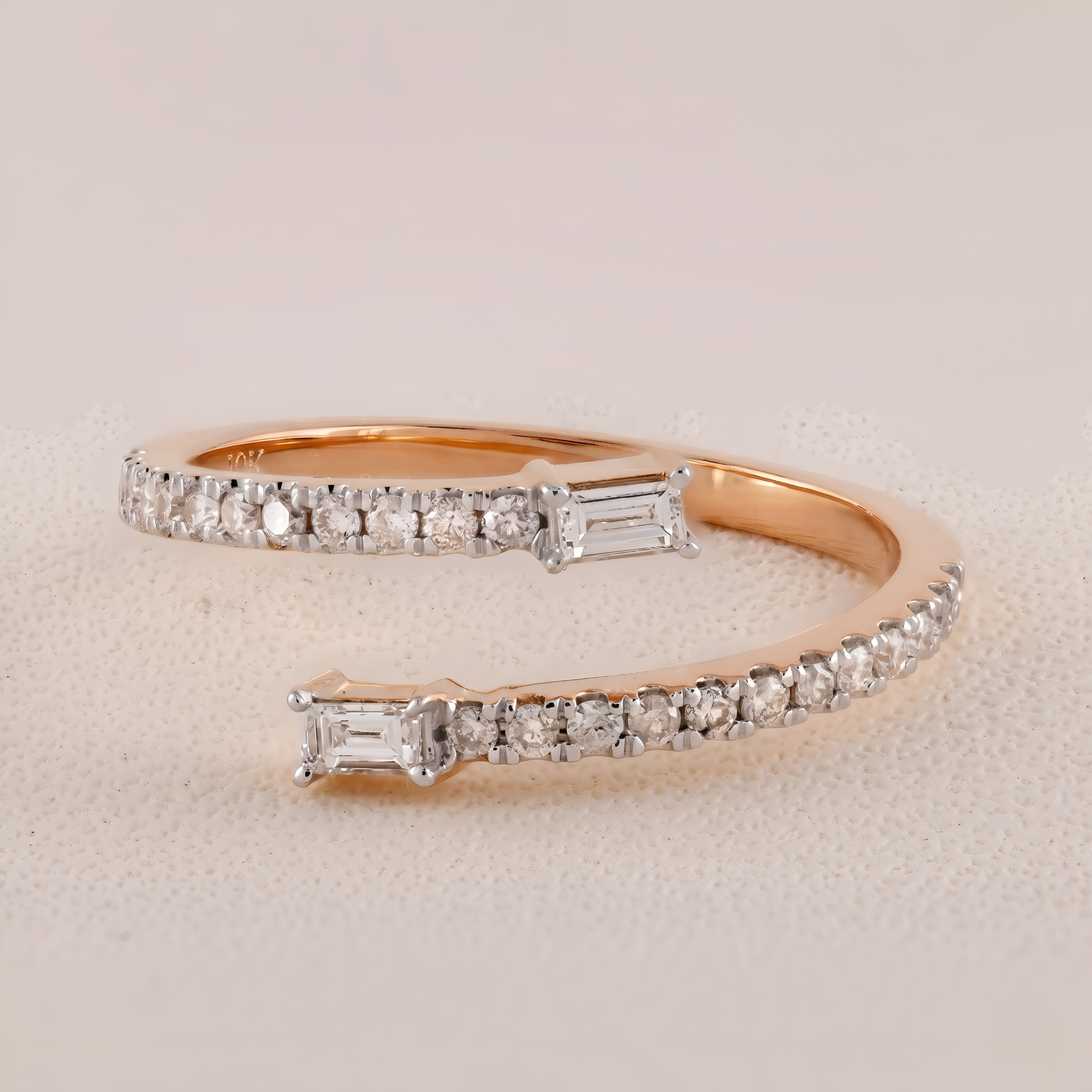 Rose gold ring with diamond accents on a beige background