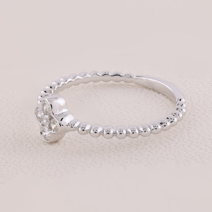 Silver ring with beaded design on a light beige background