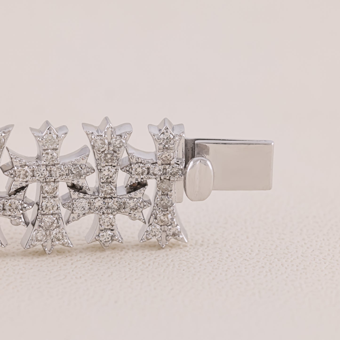 Silver earring with diamond-like stones on a beige background