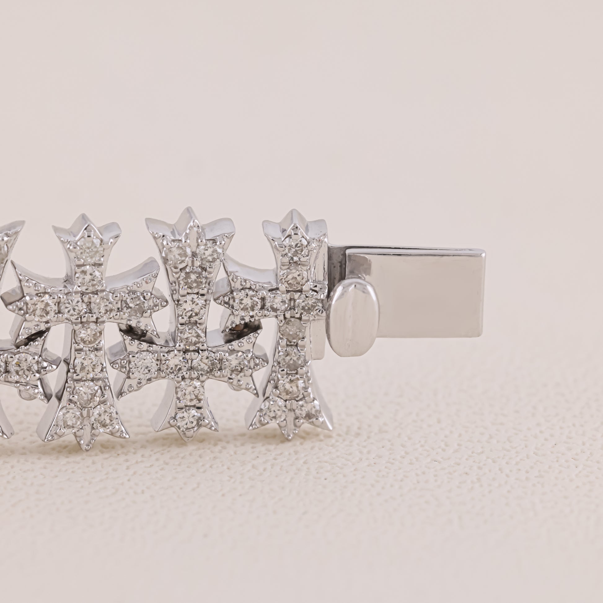 Silver earring with diamond-like stones on a beige background