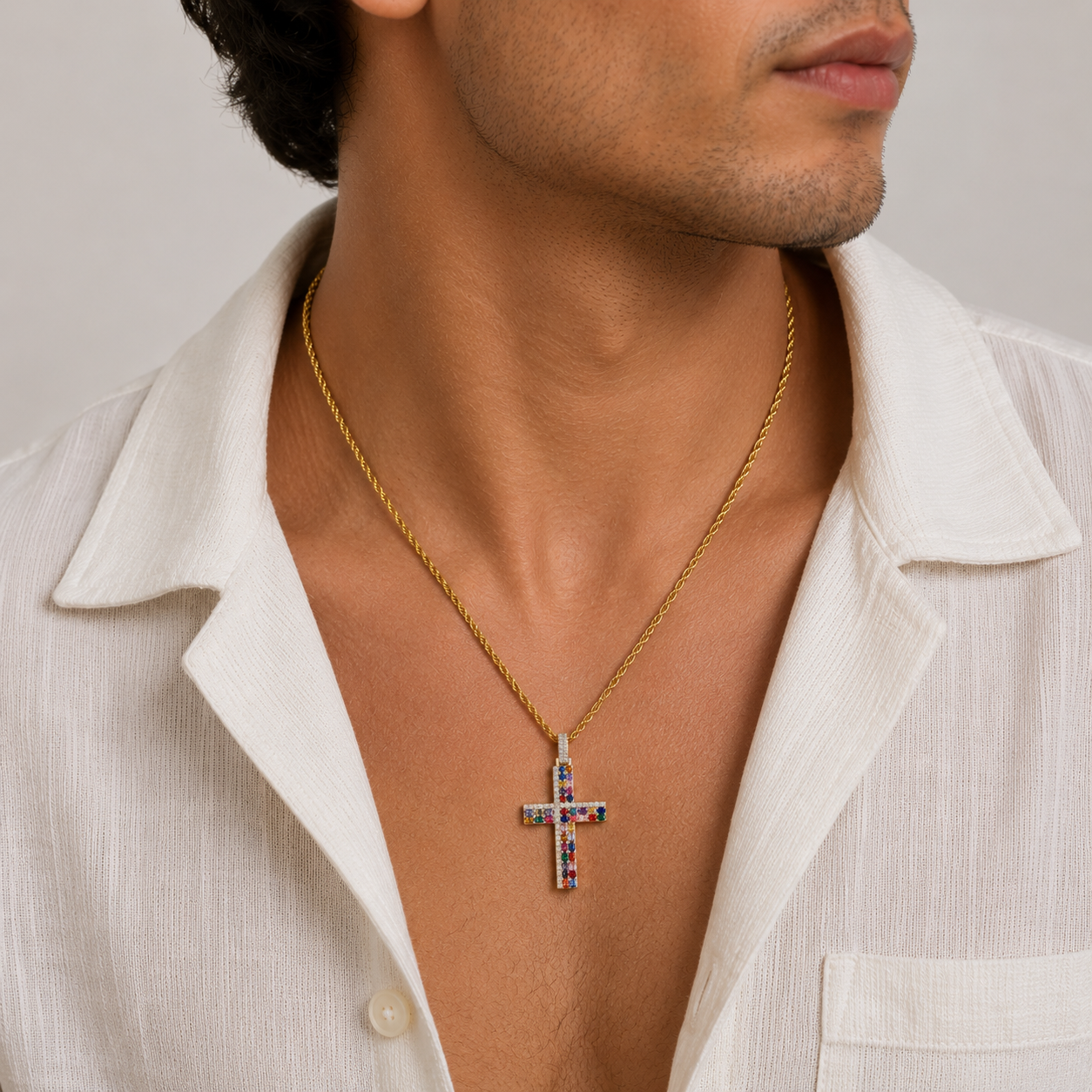 Man wearing a gold necklace with a cross pendant