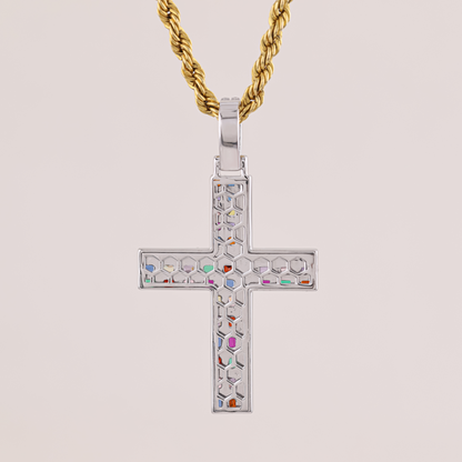 Cross-shaped pendant with colorful stones on a gold chain against a beige background
