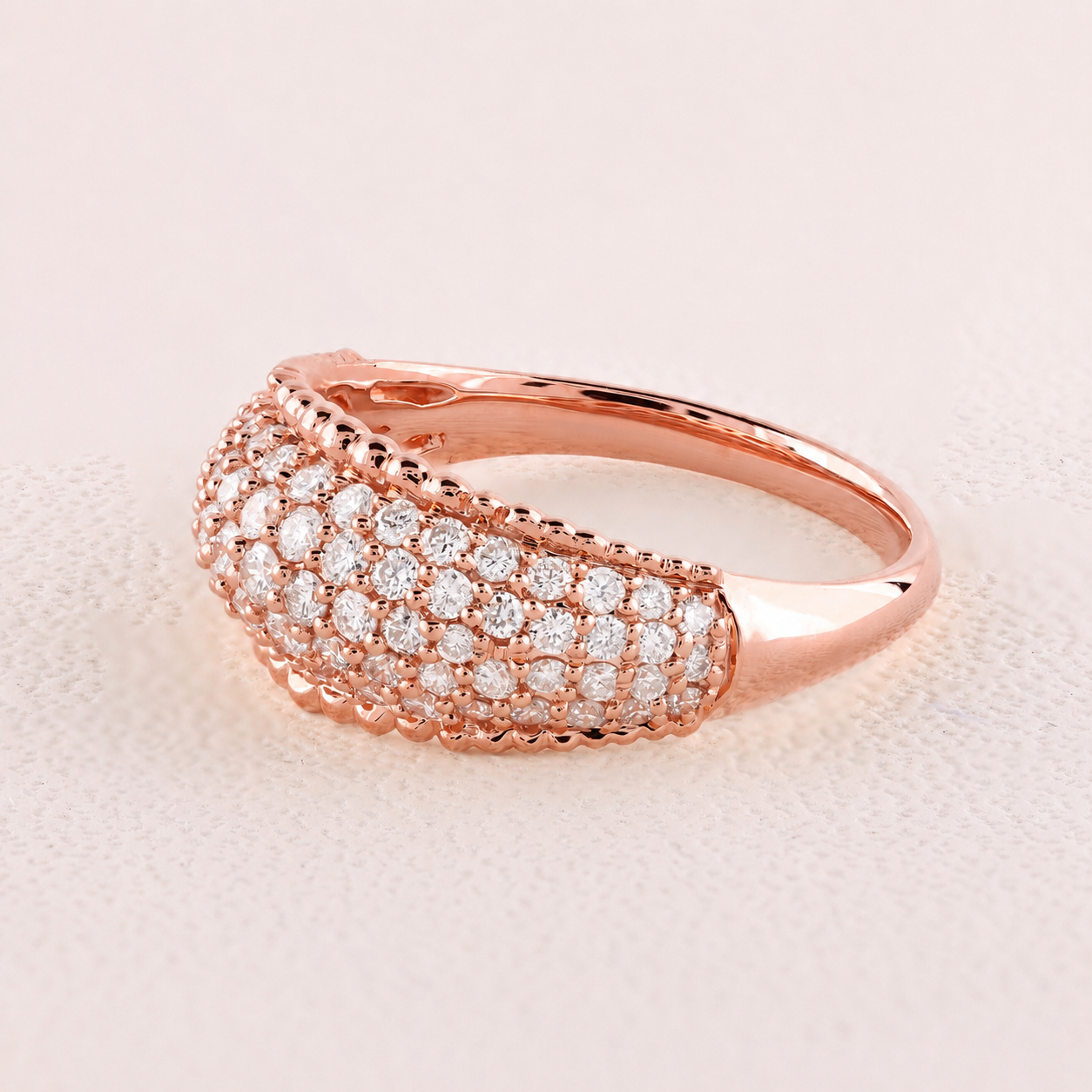 Rose gold ring with diamonds on a light pink background
