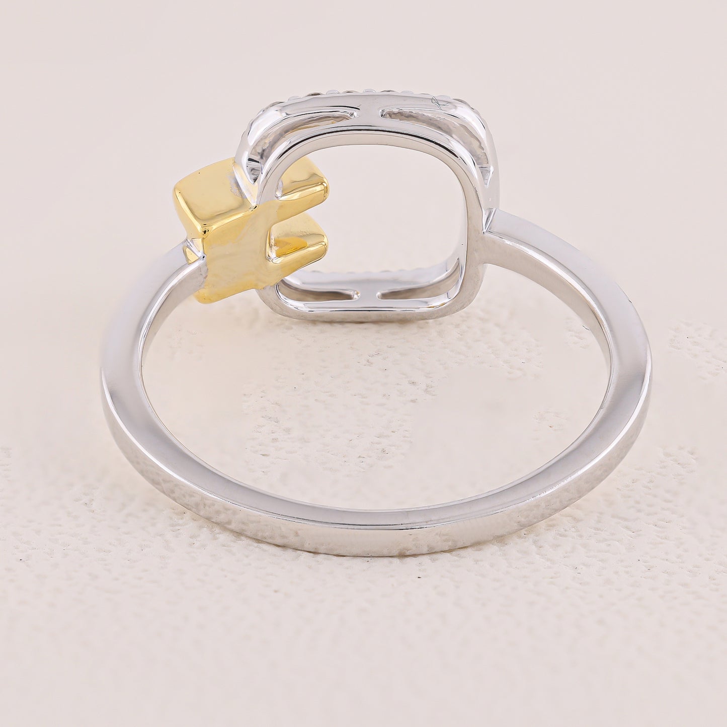 Silver ring with a gold accent on a light beige background
