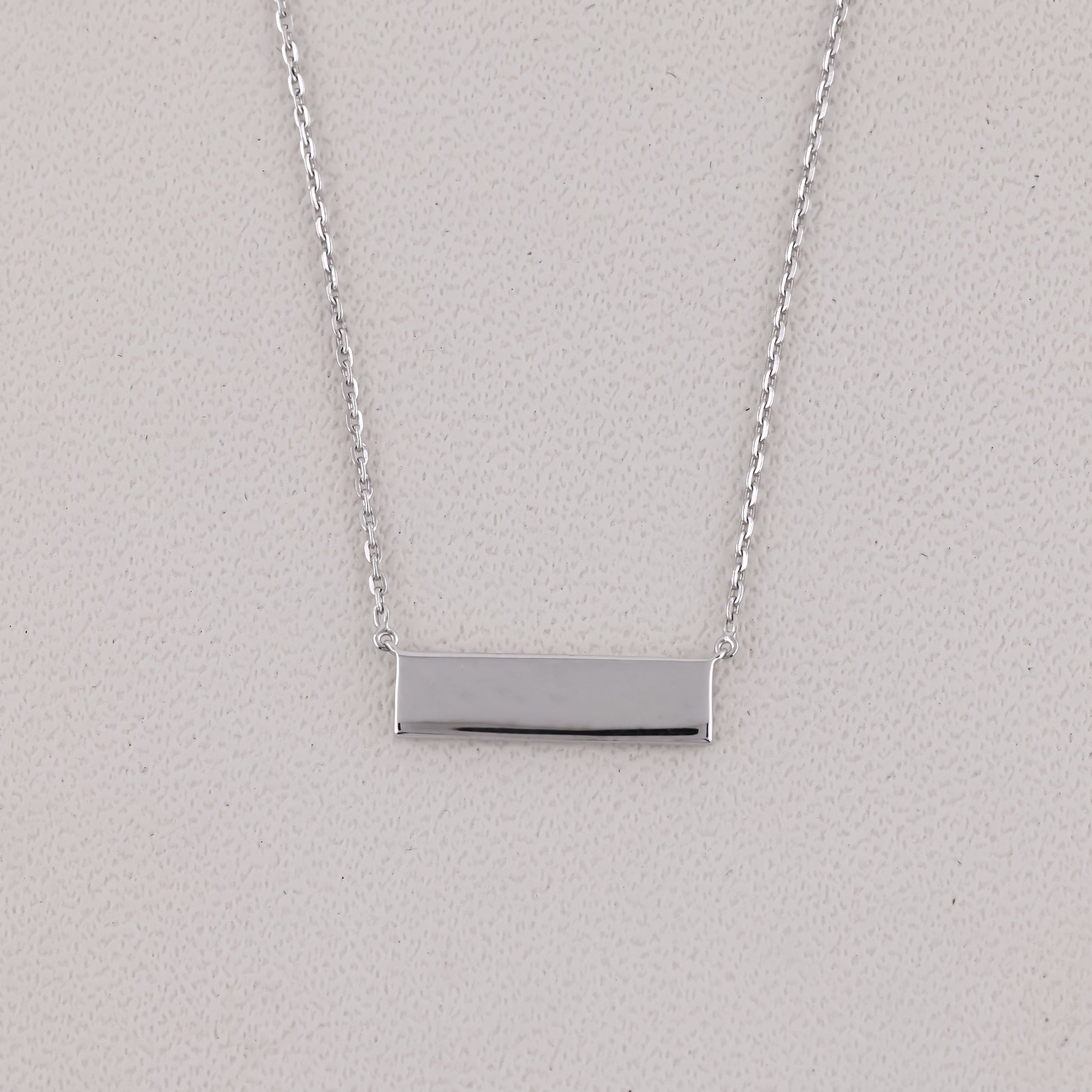 Silver bar necklace on a light gray background