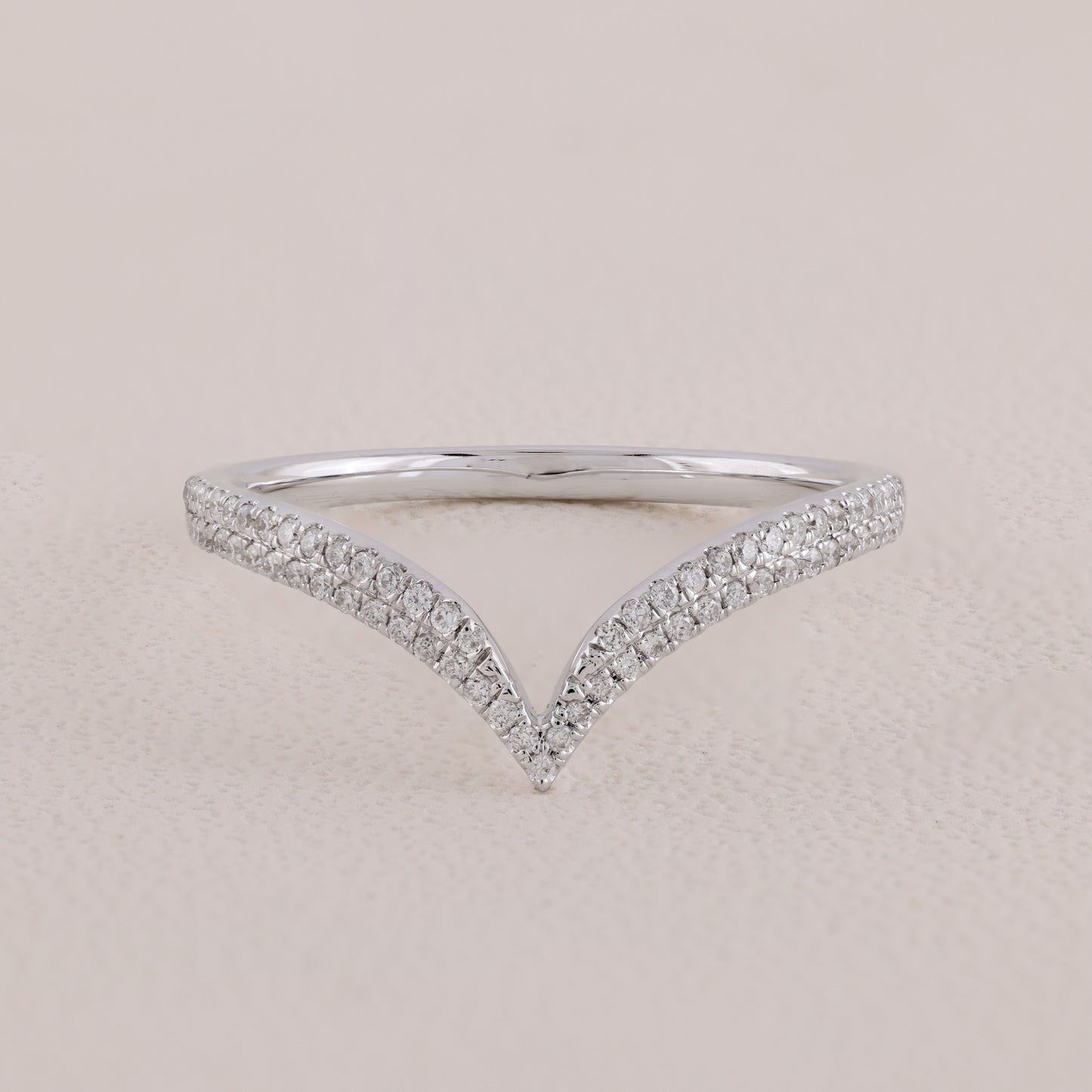Silver ring with diamond accents on a beige background
