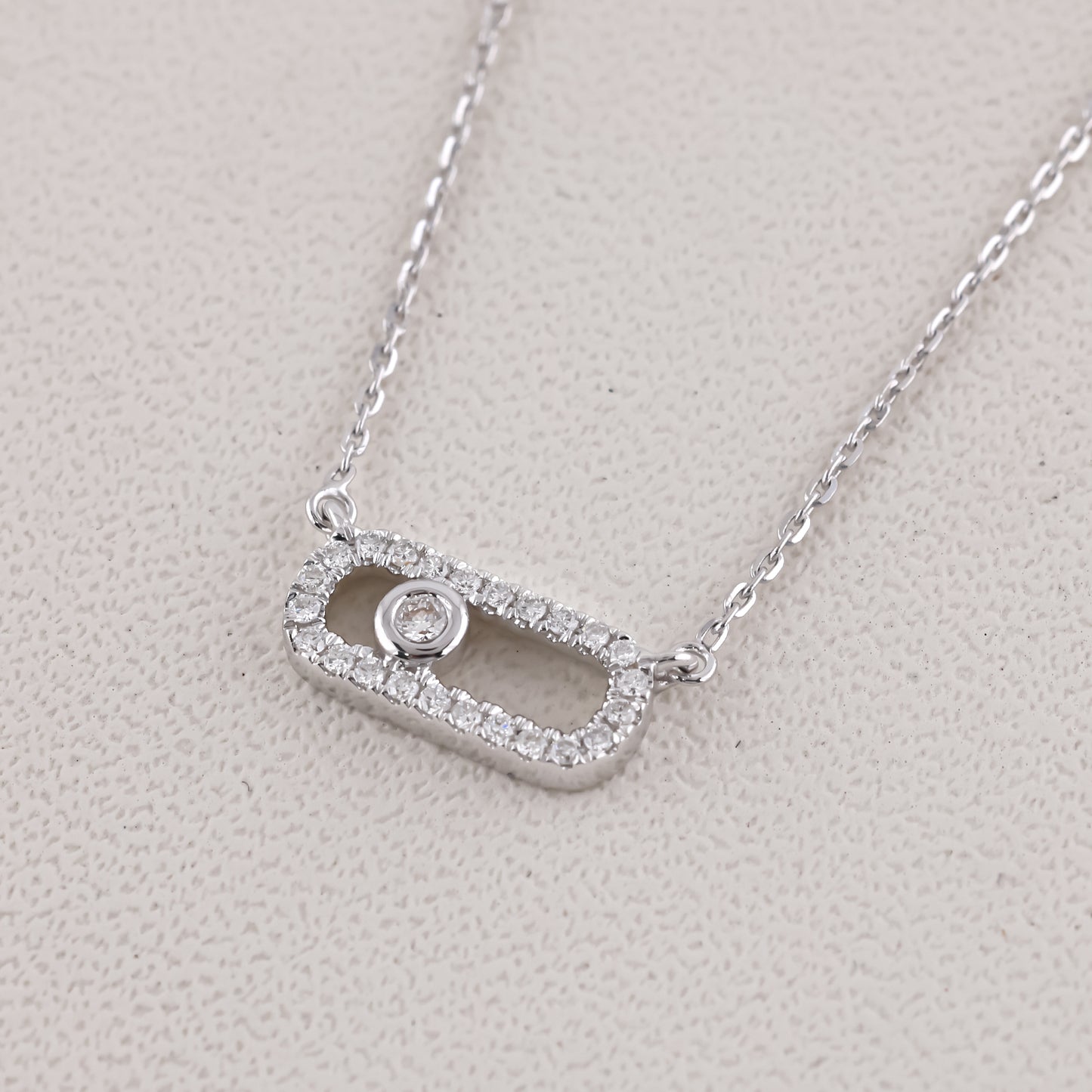 Silver necklace with a rectangular pendant on a light gray background