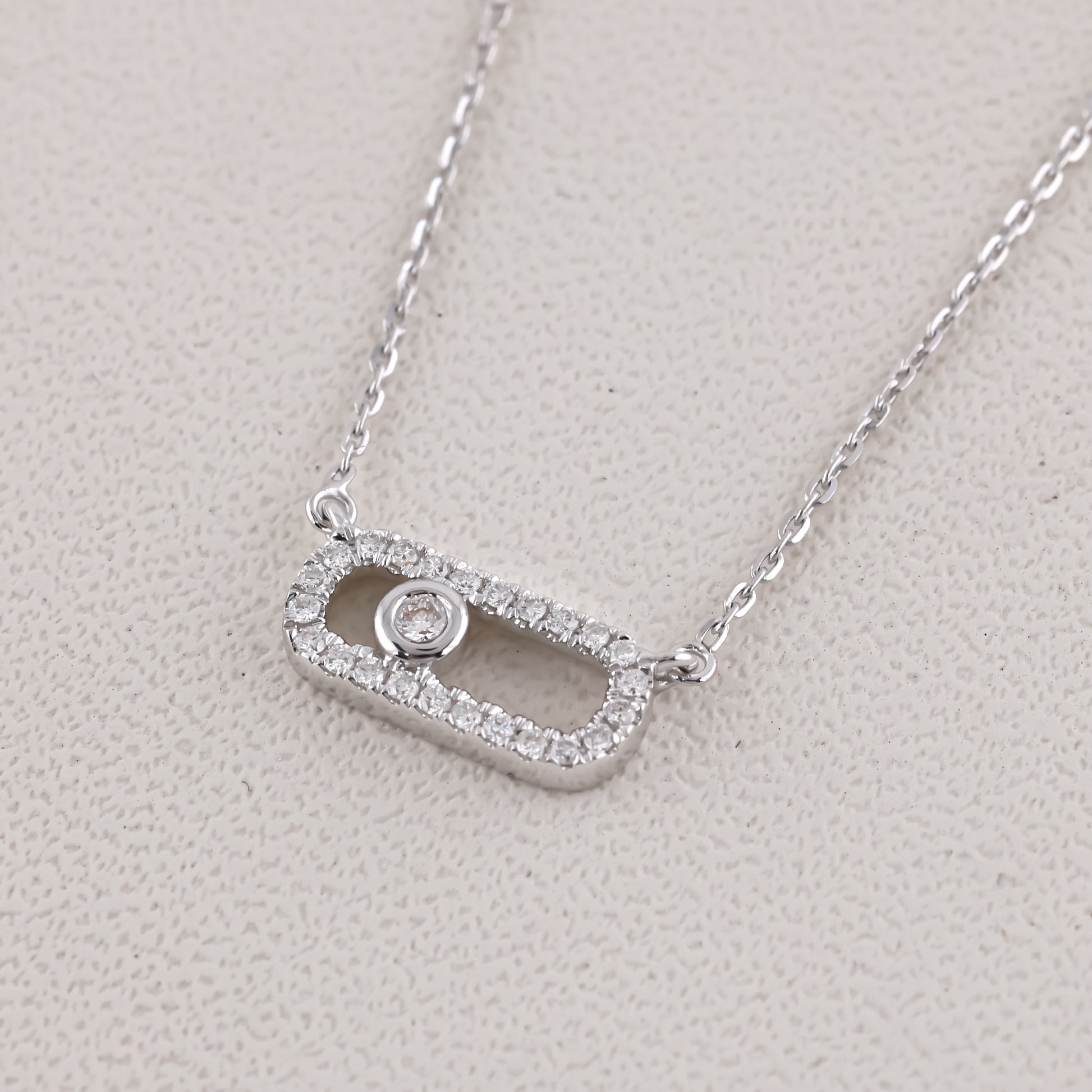 Silver necklace with a rectangular pendant on a light gray background