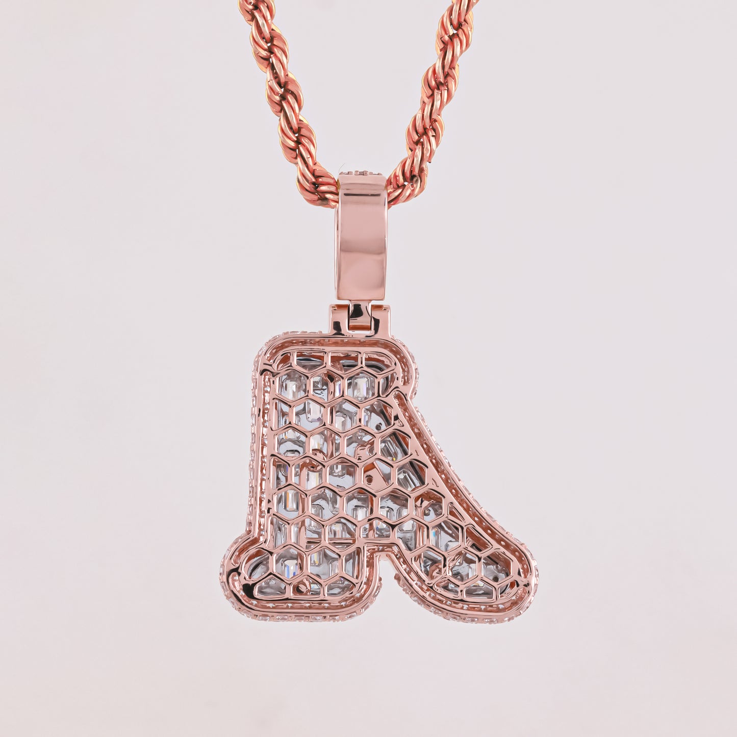 Rose gold necklace with a letter 'A' pendant on a light gray background