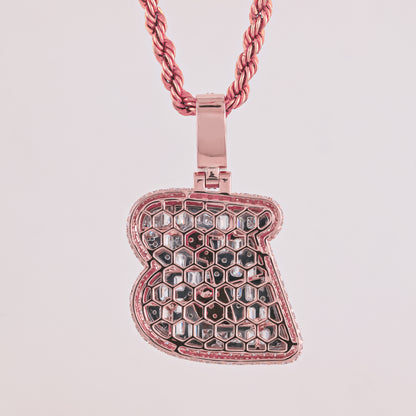 Rose gold honeycomb pendant on a pink chain against a light pink background