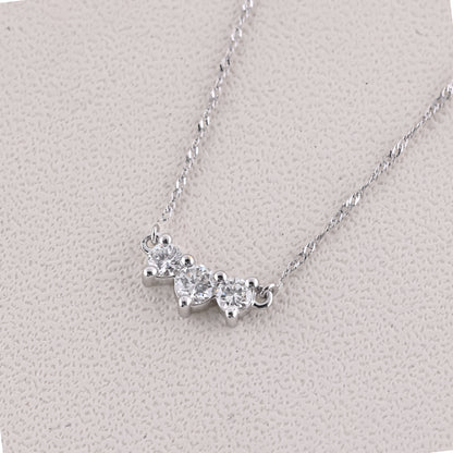 Silver necklace with heart-shaped pendants on a light gray background
