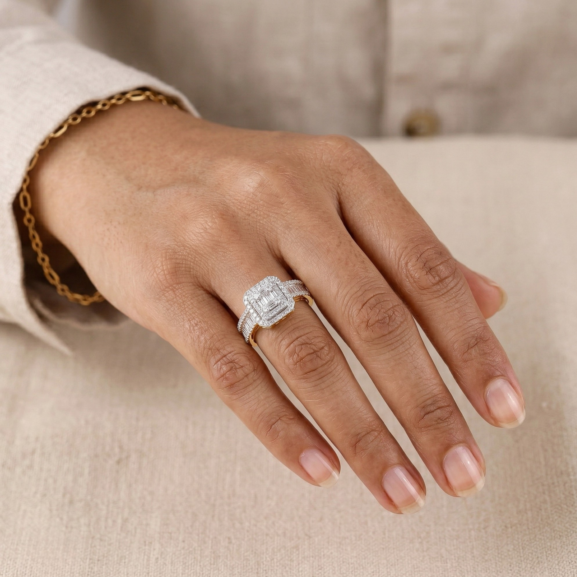 Hand wearing a silver ring with a diamond on a neutral background