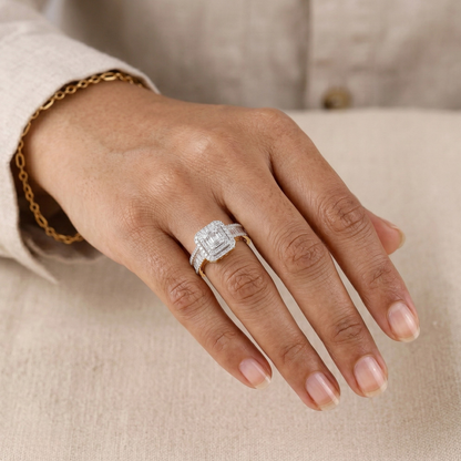 Hand wearing a silver ring with a diamond on a neutral background