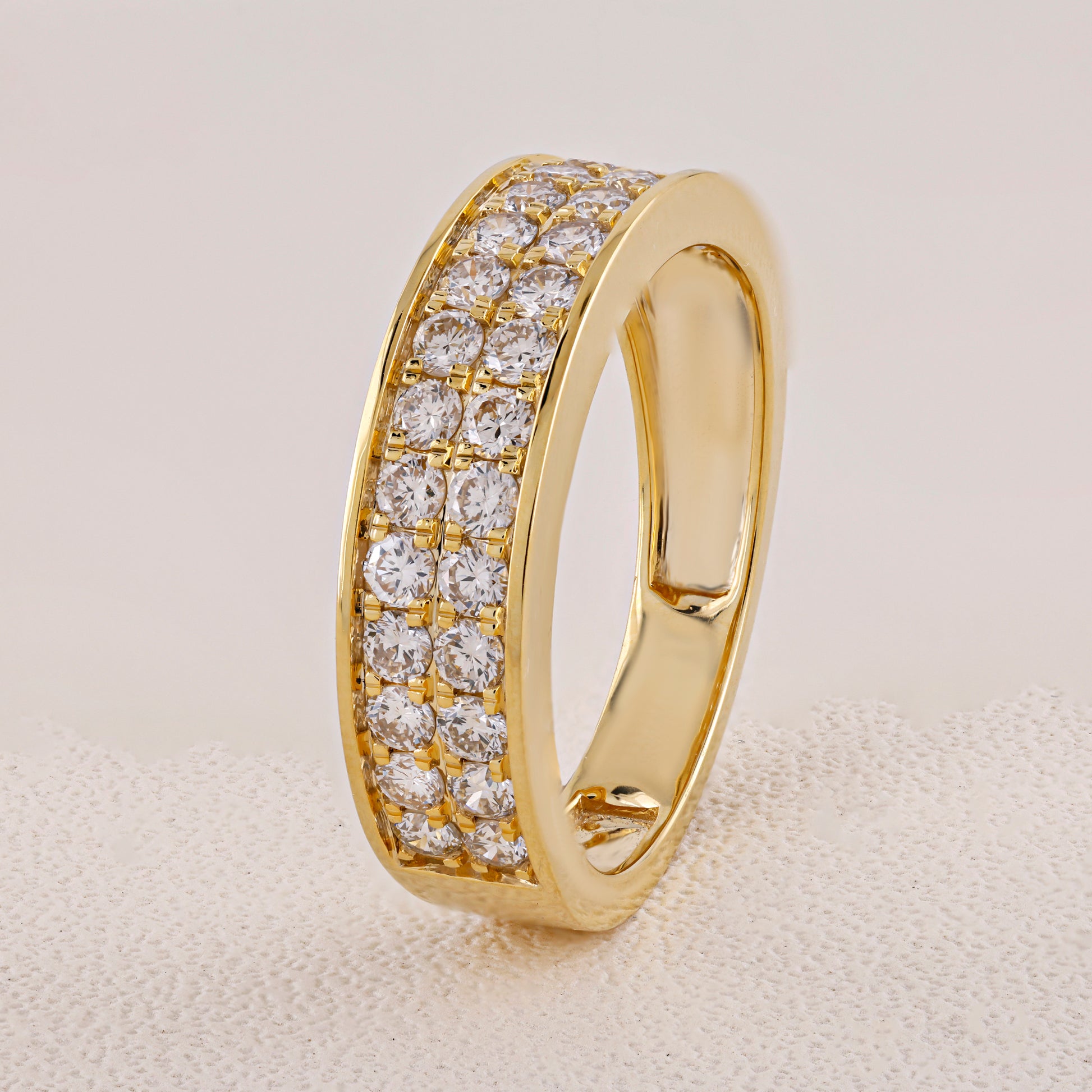 Gold ring with diamond stones on a beige background