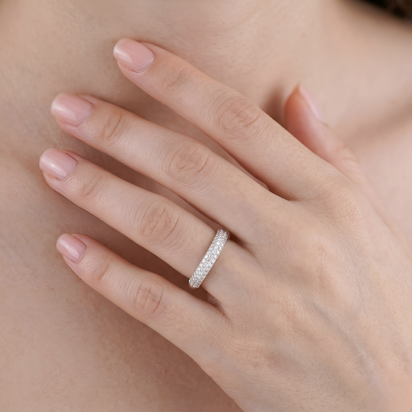 Close-up of a hand wearing a diamond ring with a soft focus background