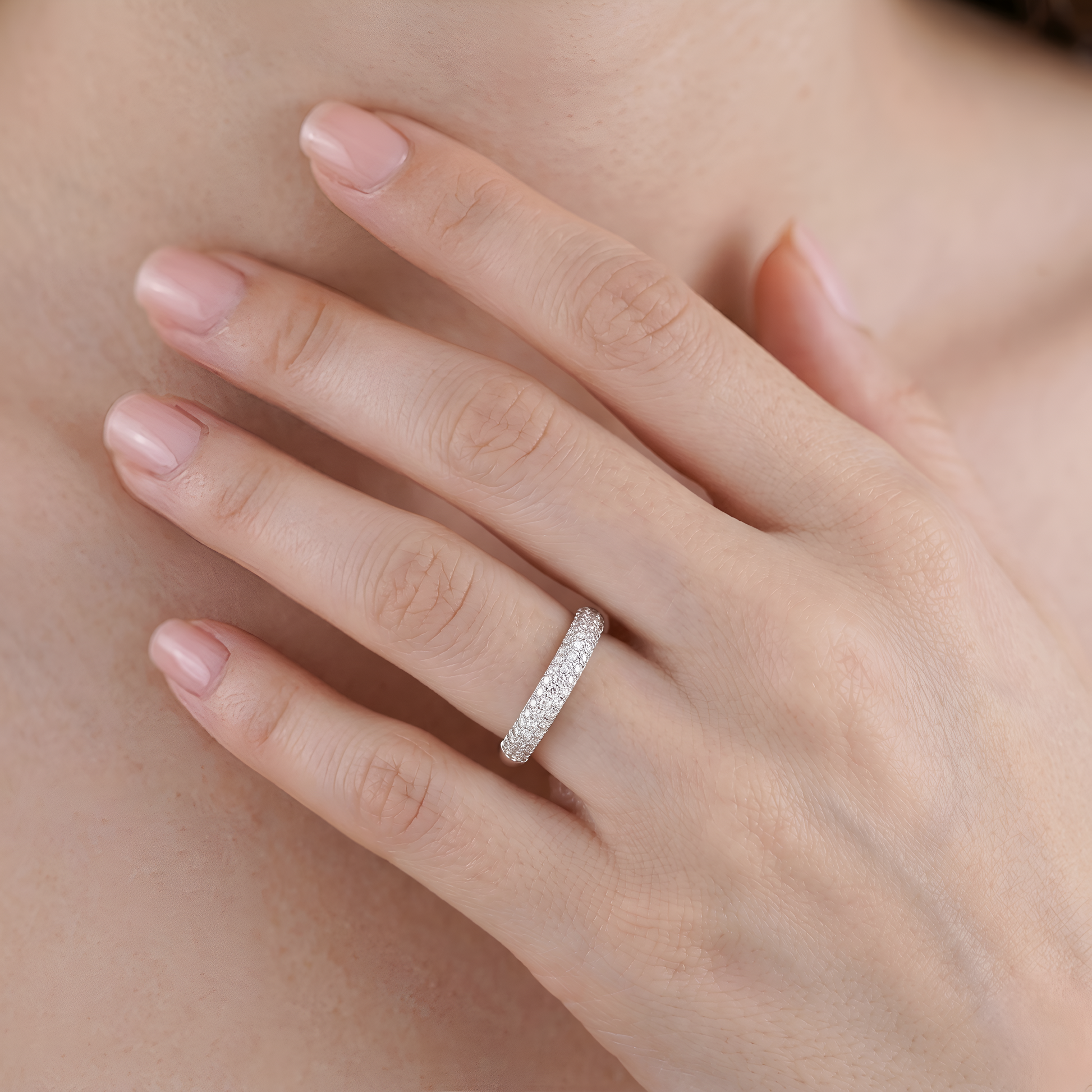 Close-up of a hand wearing a diamond ring with a soft focus background
