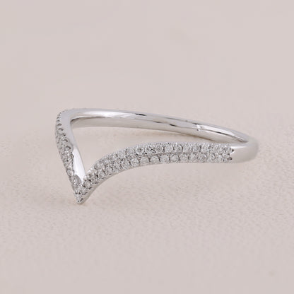 Silver ring with small diamonds on a light beige background