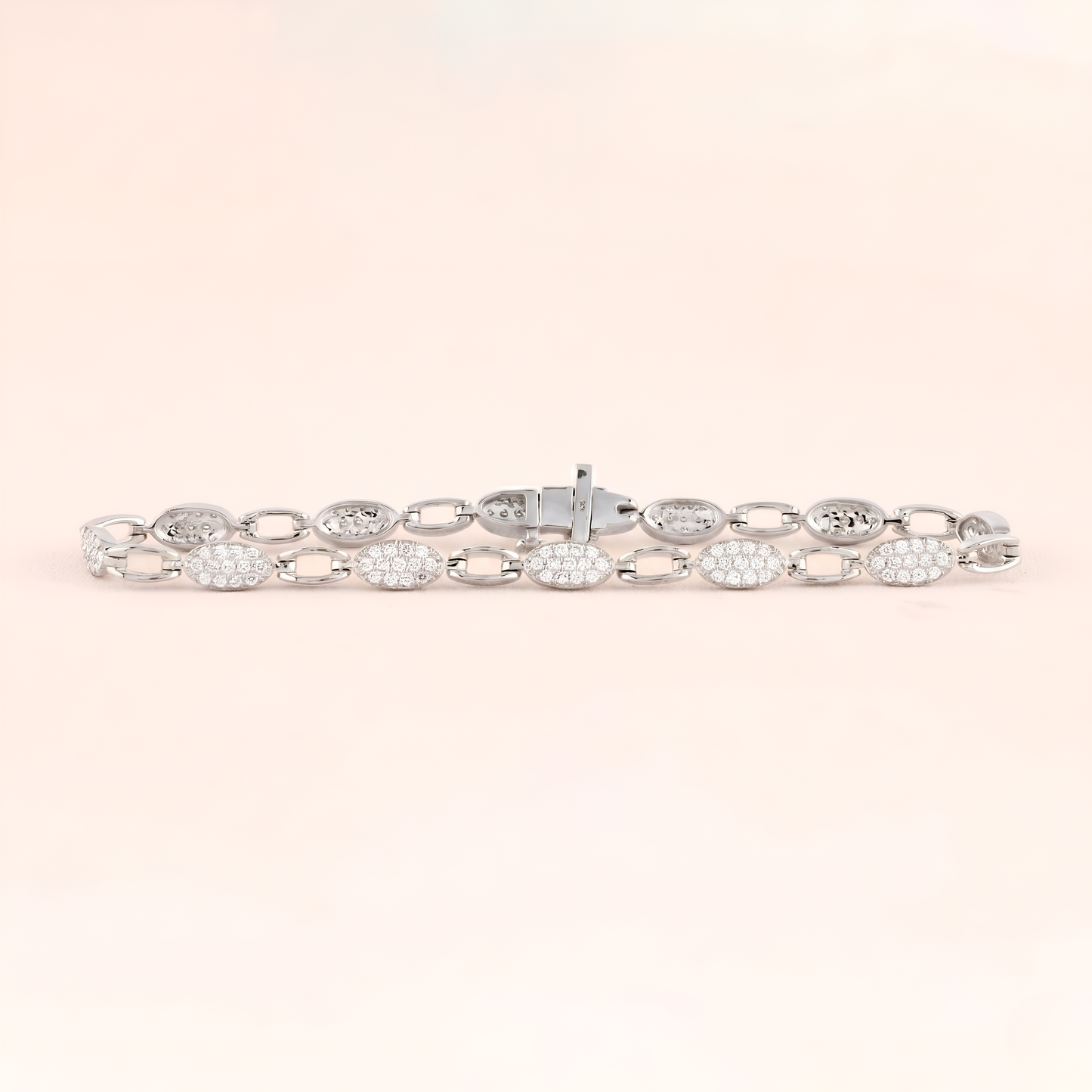 Silver bracelet with clear stones on a light pink background