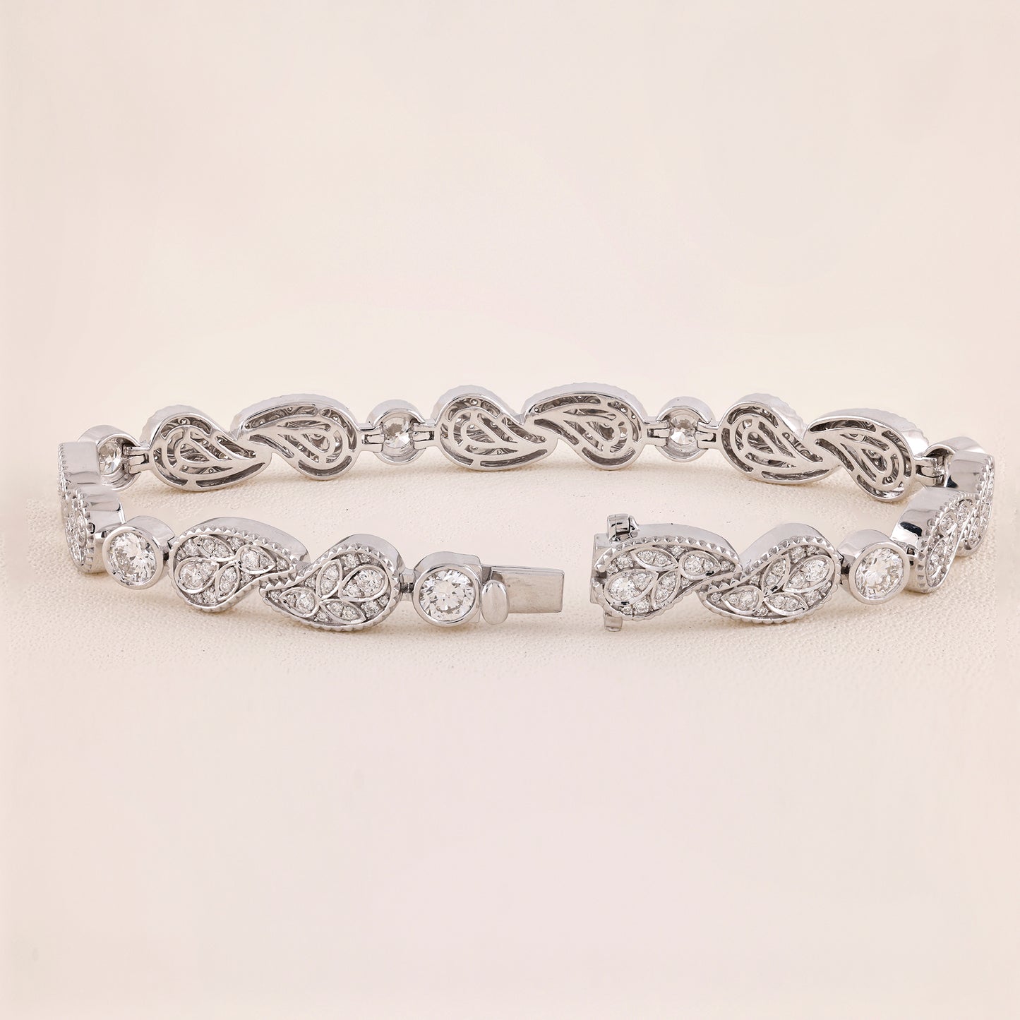Silver bracelet with intricate design on a light beige background
