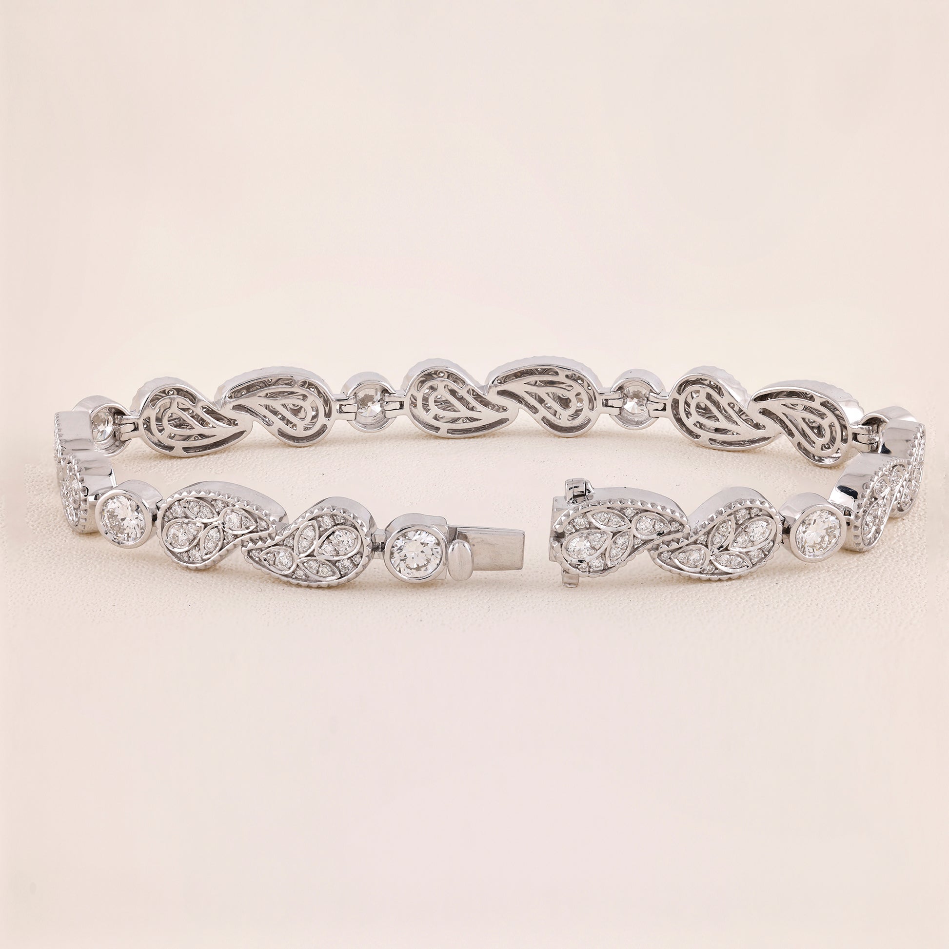 Silver bracelet with intricate design on a light beige background