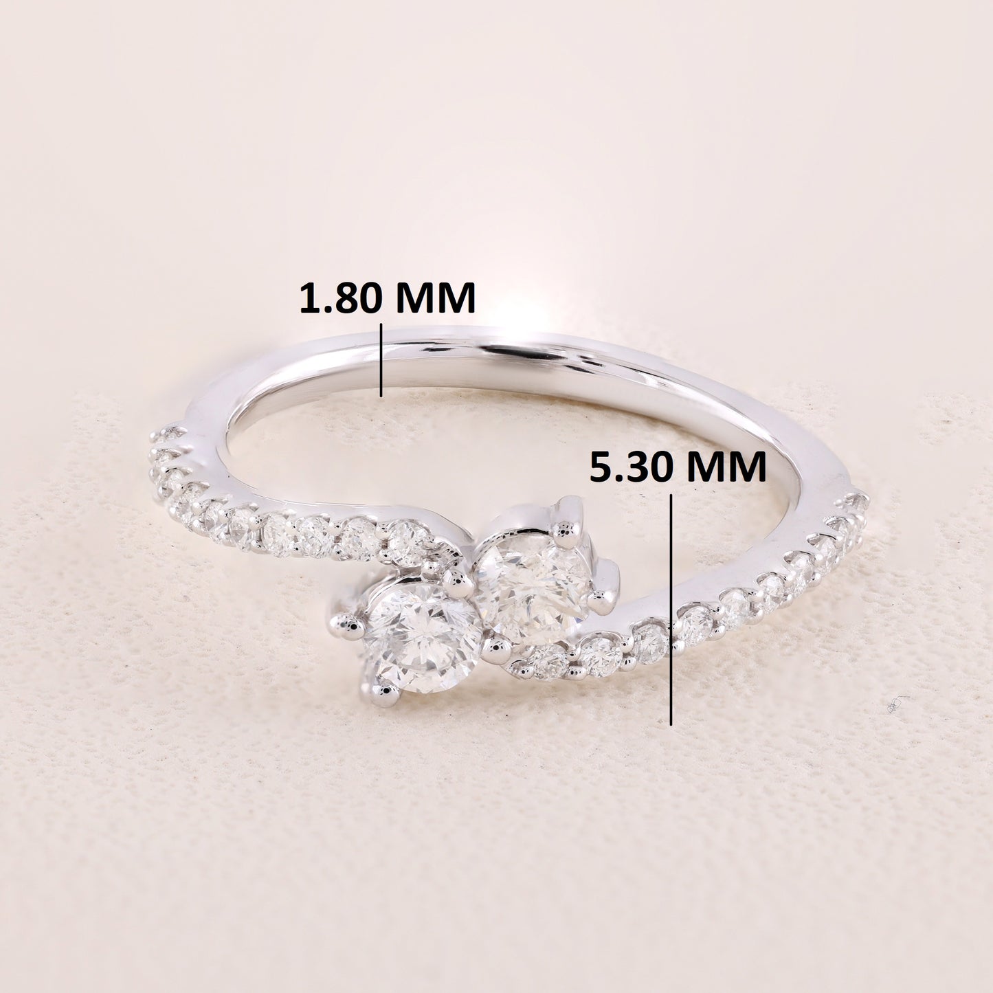Silver ring with diamond measurements on a beige background