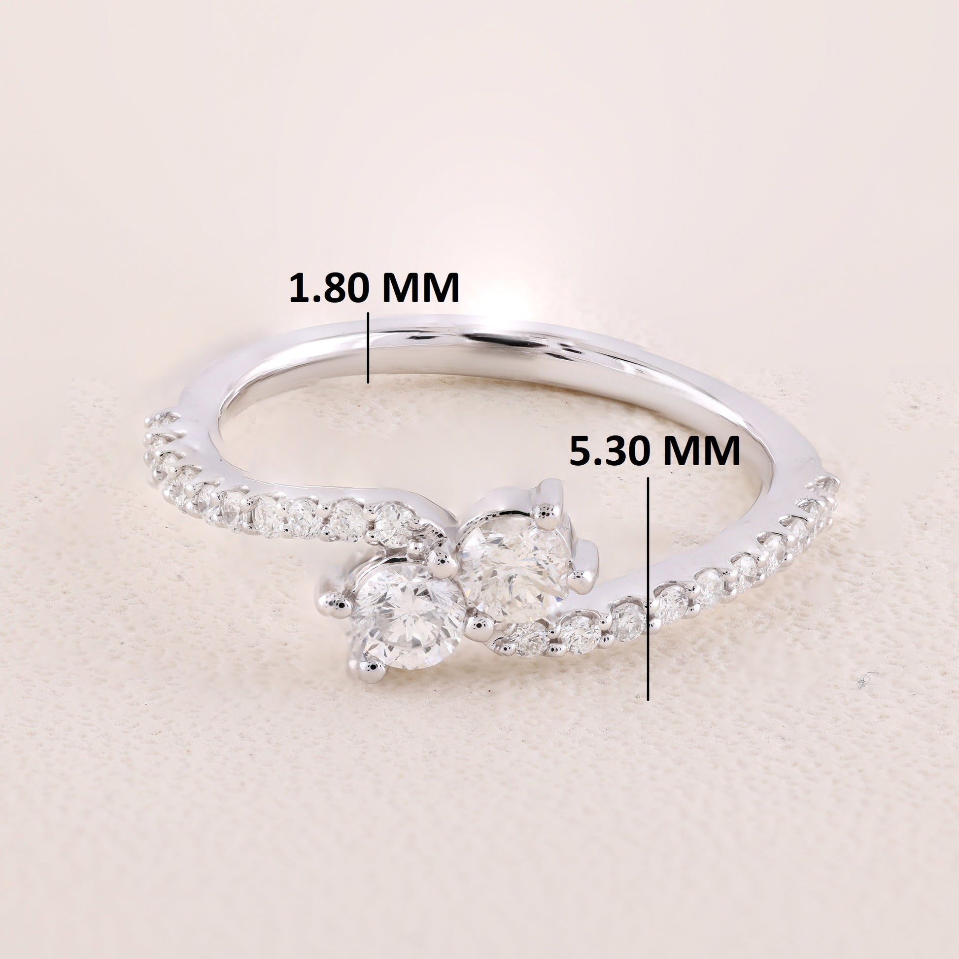 Silver ring with diamond measurements on a beige background