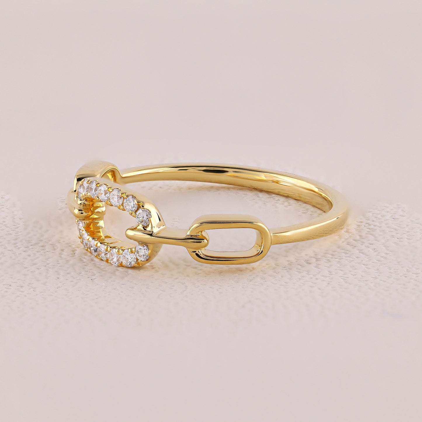 Gold ring with diamond accents on a beige background