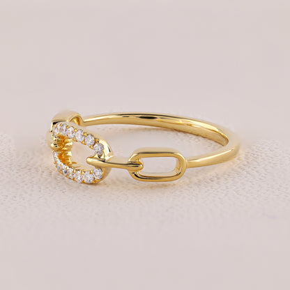 Gold ring with diamond accents on a beige background
