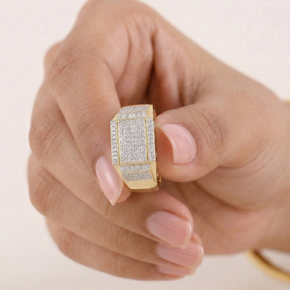 Gold ring with diamonds on a hand against a light background