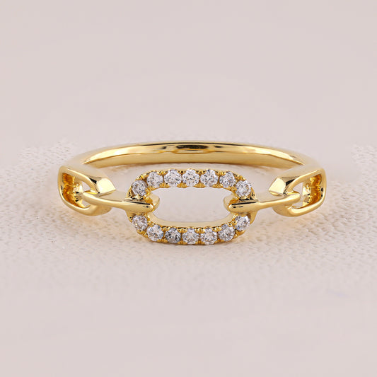 Gold ring with diamond accents on a light pink background
