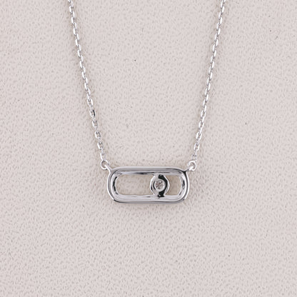 Silver necklace with a rectangular pendant on a light gray background