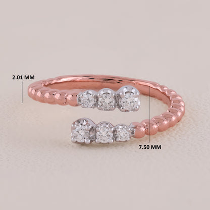 Rose gold ring with diamond accents on a light beige background