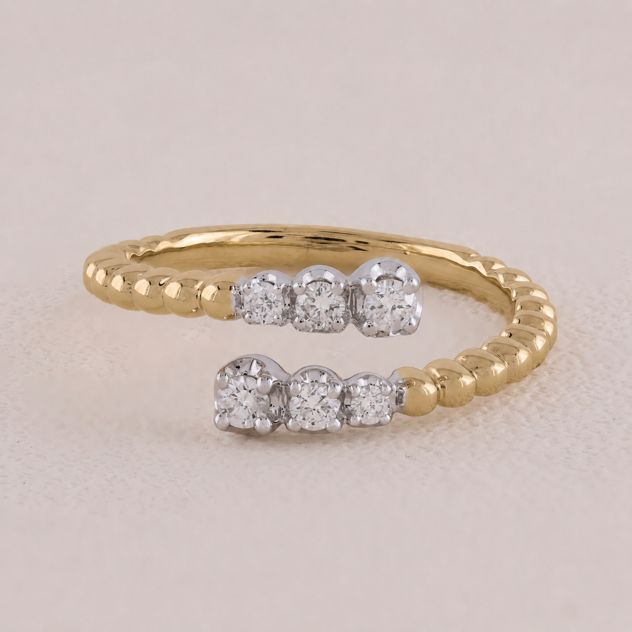 Gold ring with embedded diamonds on a beige background