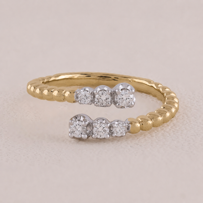 Gold ring with embedded diamonds on a beige background