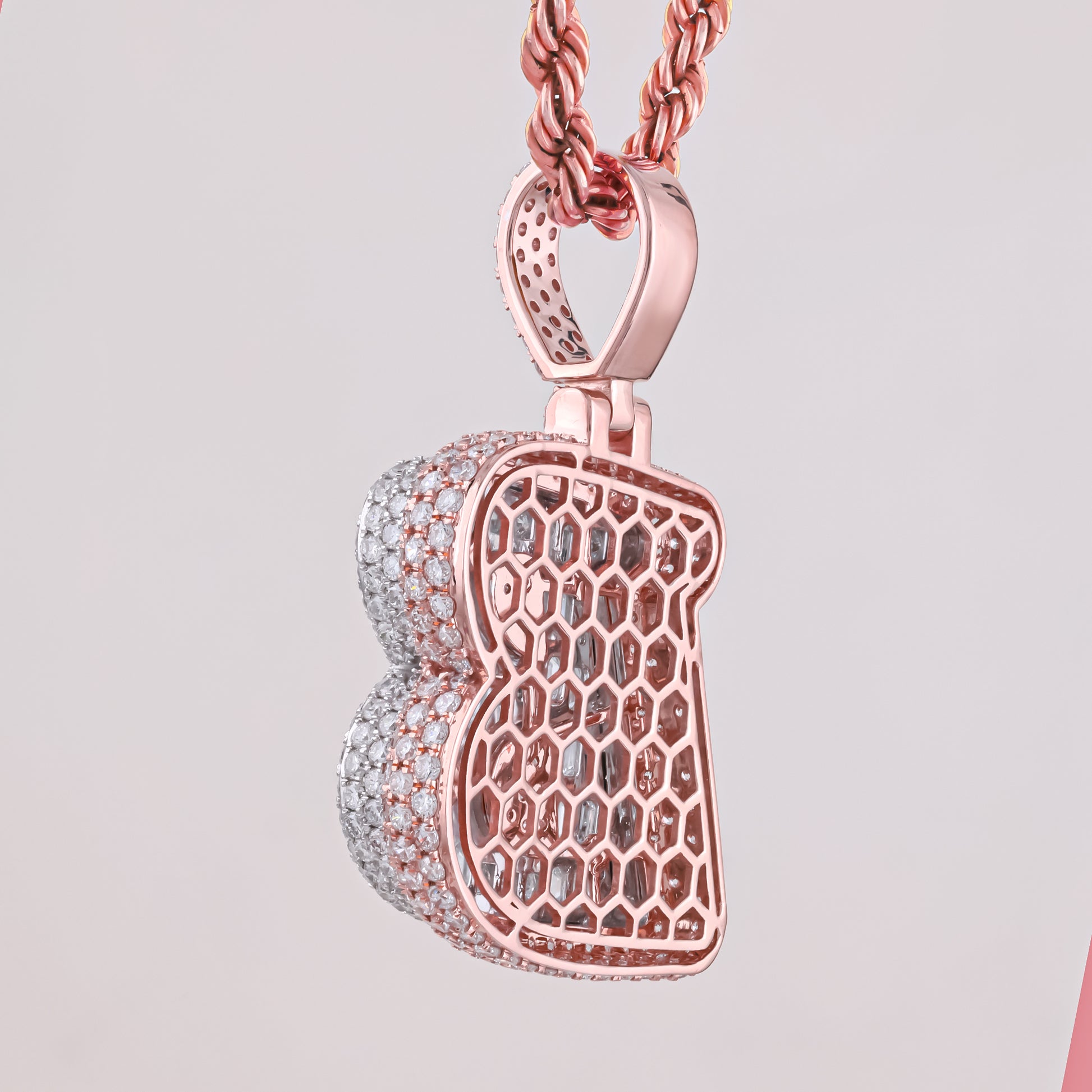 Rose gold and silver honeycomb pendant on a light gray background