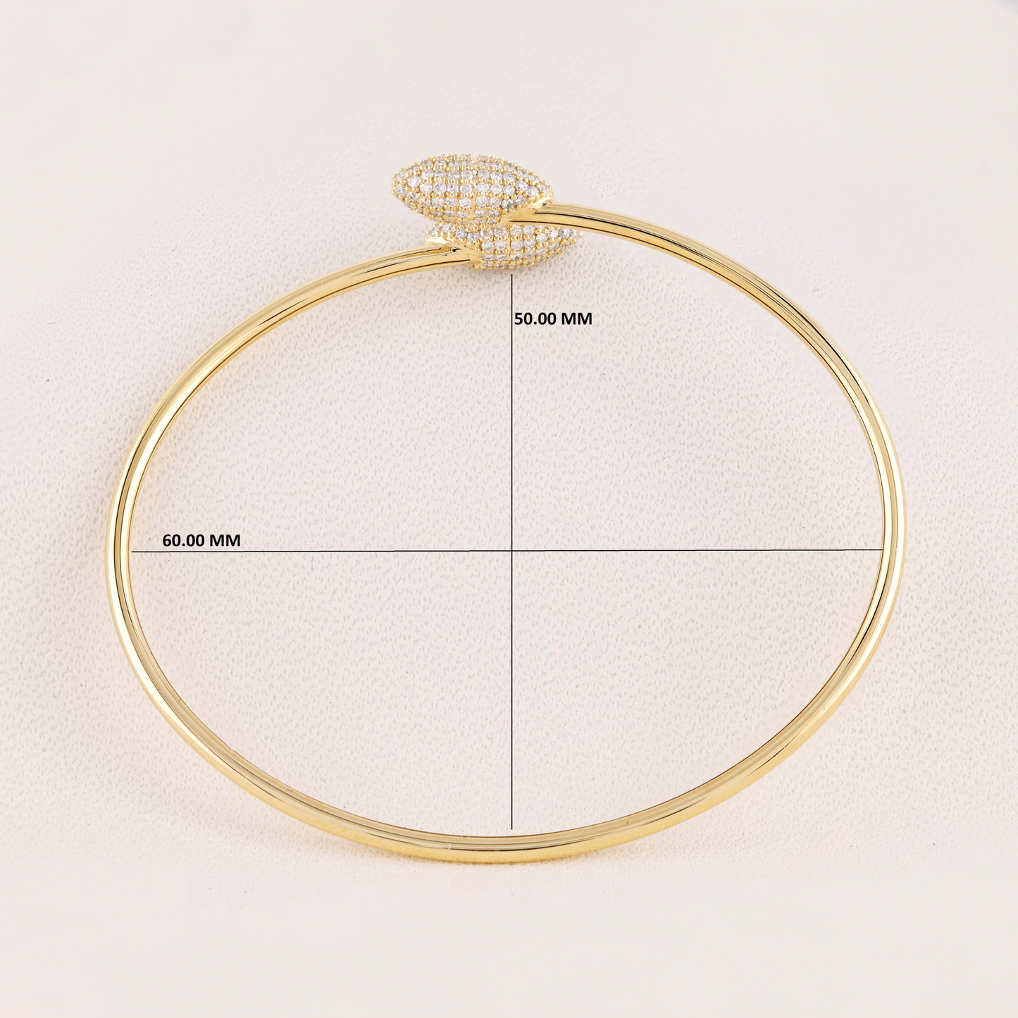 Gold bangle with measurement details on a light background