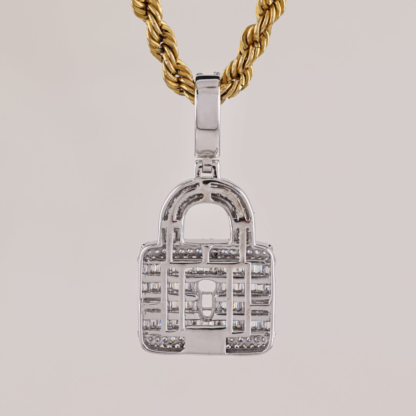 Silver padlock-shaped pendant on a gold chain against a light gray background