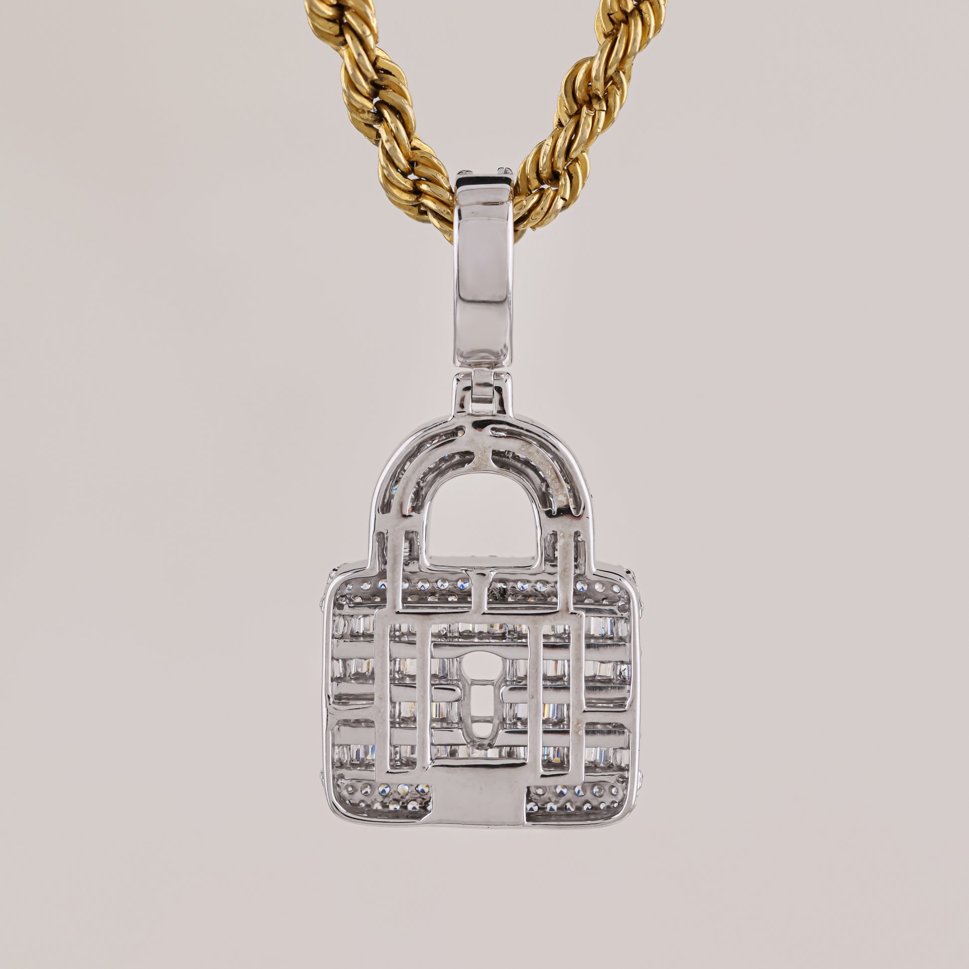 Silver padlock-shaped pendant on a gold chain against a light gray background