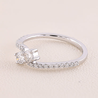 Silver ring with two diamonds on a beige background