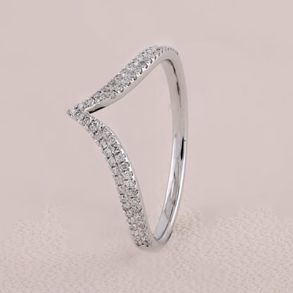 Silver ring with diamond accents on a beige background