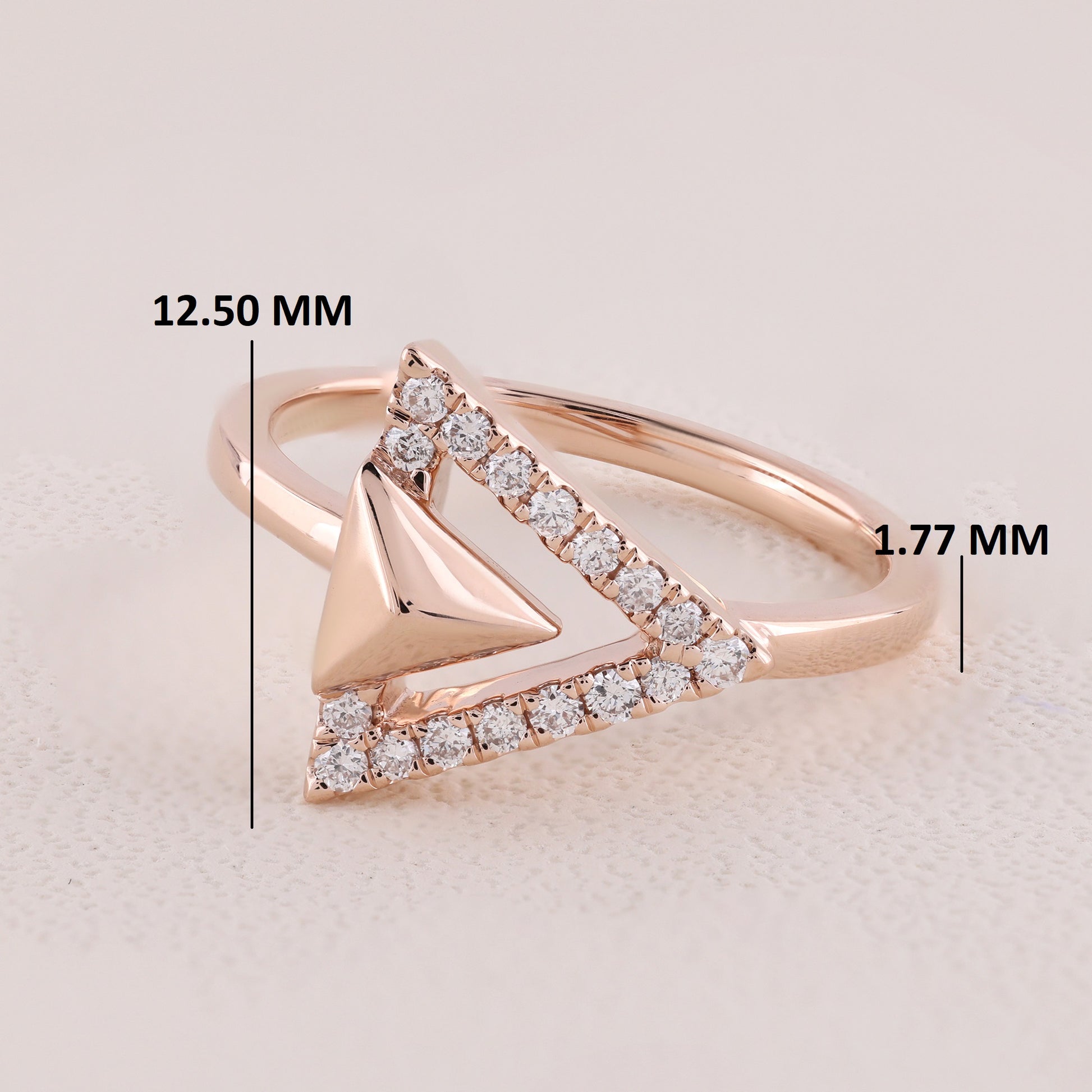 Rose gold ring with diamond accents and measurements on a light background