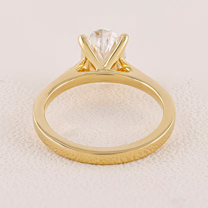 Gold ring with a clear gemstone on a textured beige background