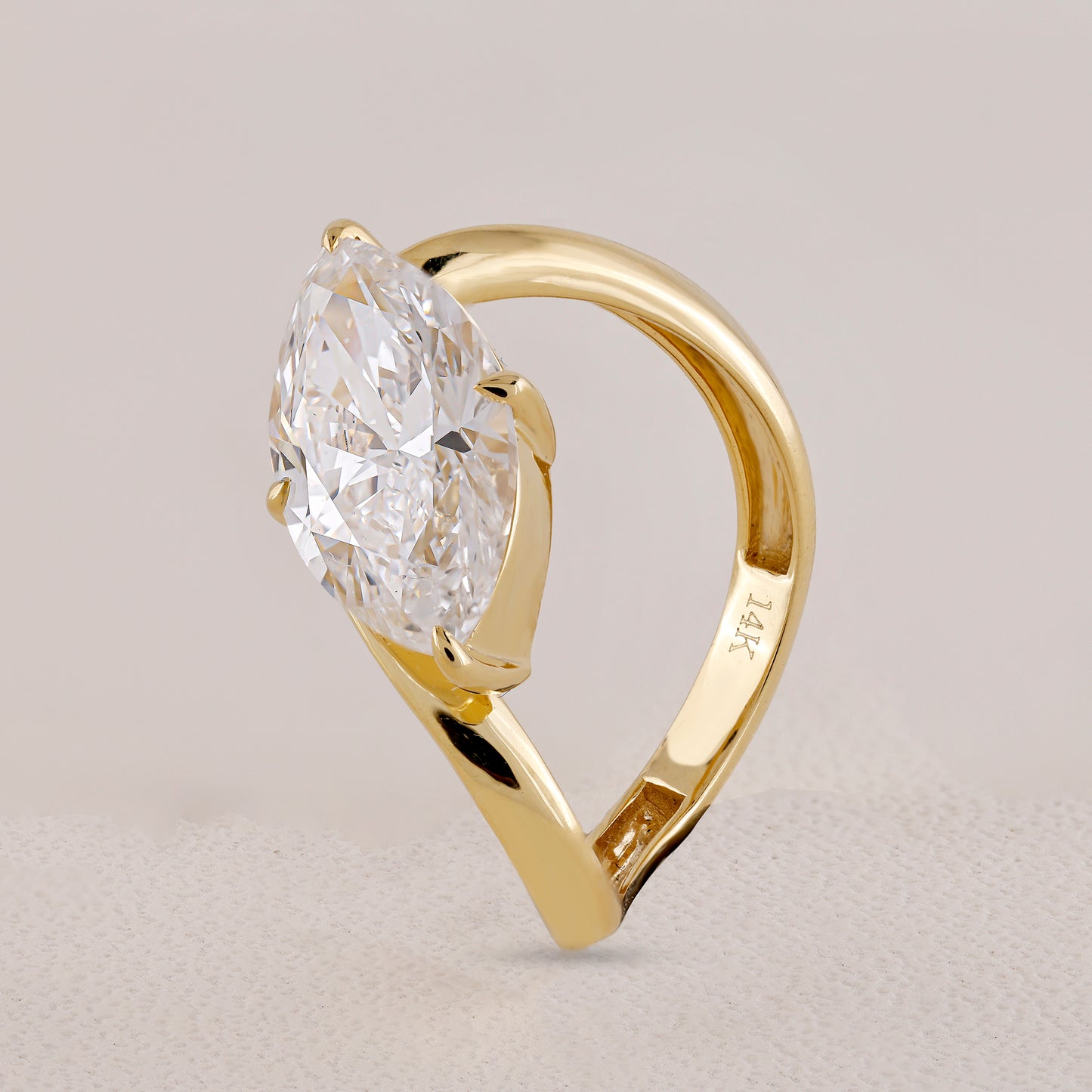 Gold ring with a large diamond on a light gray background