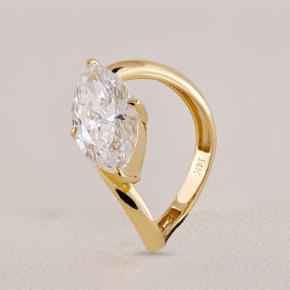 Gold ring with a large diamond on a light gray background