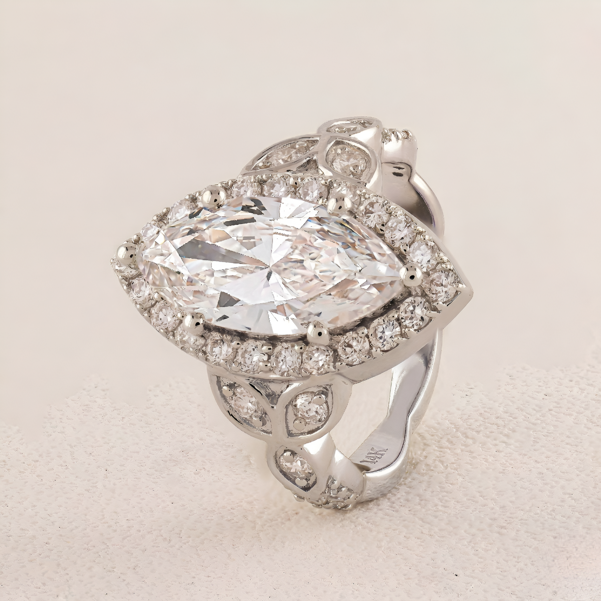 White Gold ring with a large central diamond and smaller diamonds around on a light background