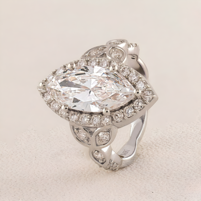 White Gold ring with a large central diamond and smaller diamonds around on a light background