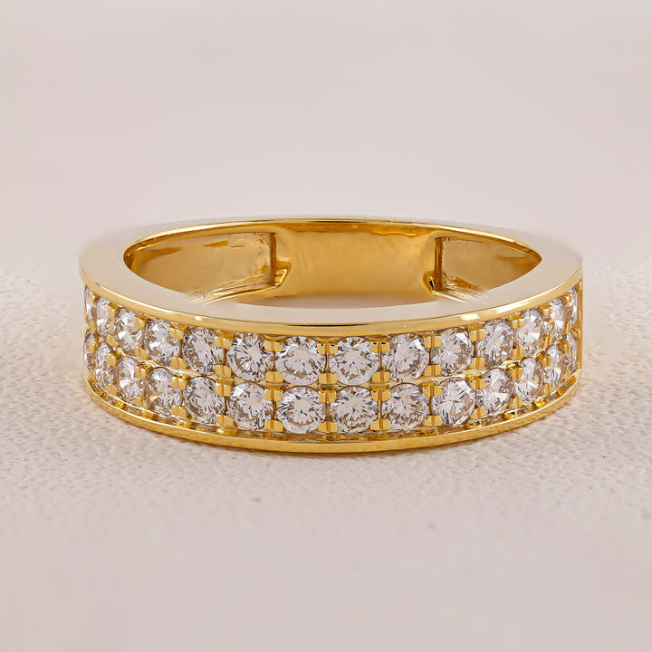 Gold ring with diamond stones on a light gray background
