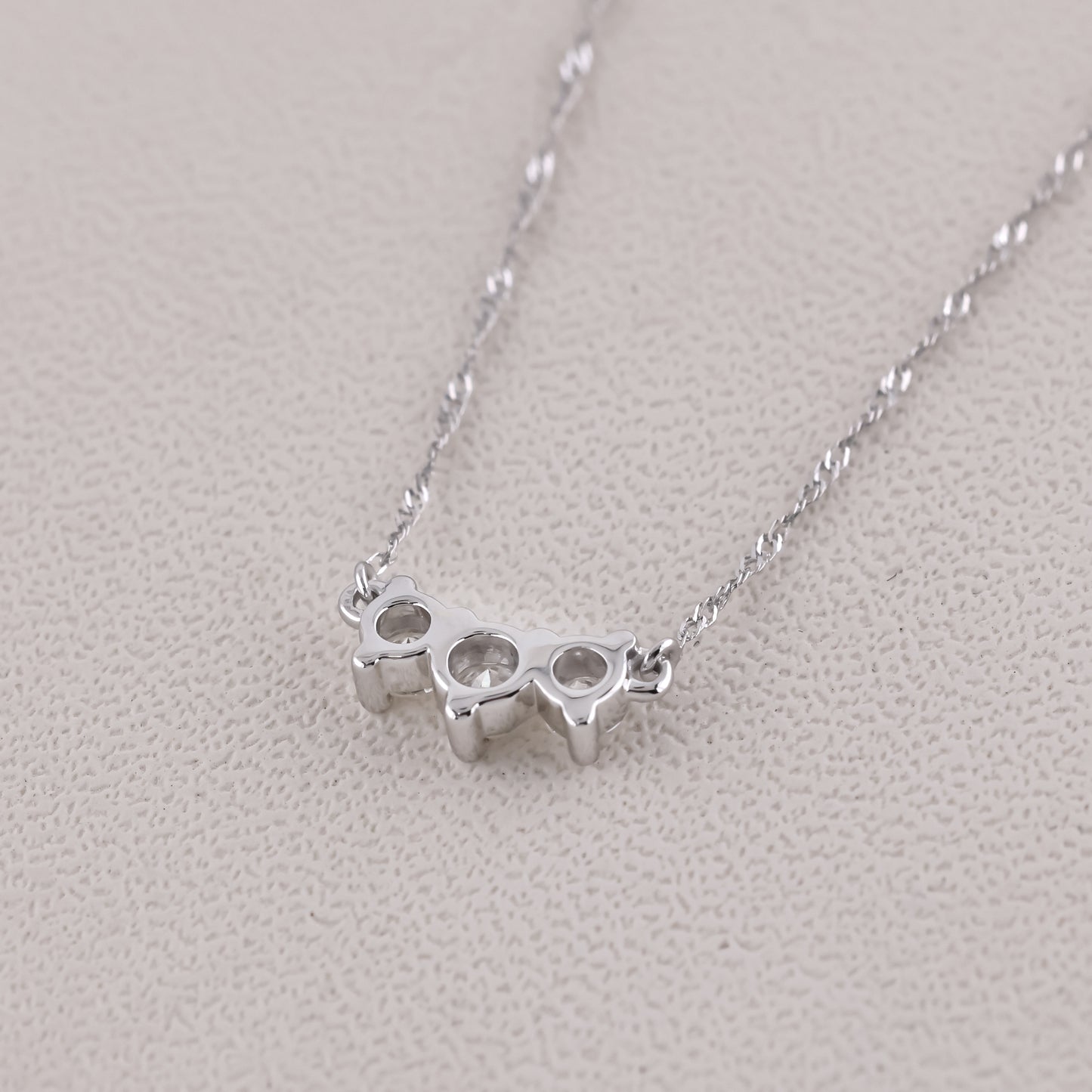 Silver knuckle duster necklace on a light gray background